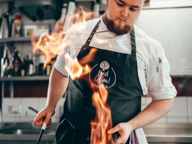 Koch flambiert essen im Restaurant im Swisttal