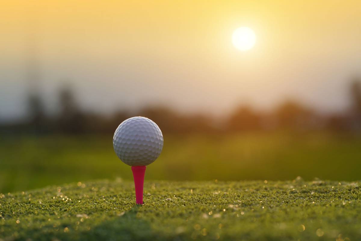Golfball auf Golfplatz im Sonnenuntergang