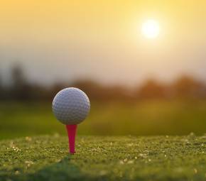 Golfball auf Golfplatz im Sonnenuntergang