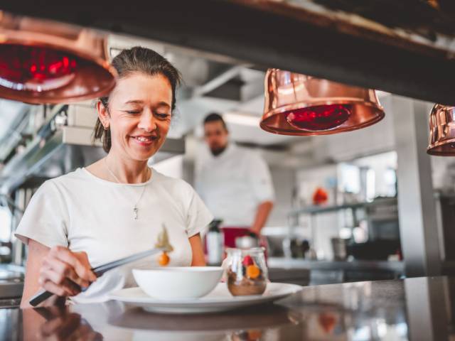 Hotelpersonal dekoriert Dessert-Teller in der Hotelküche