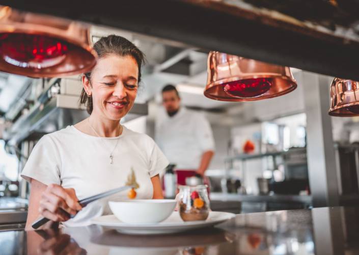 Hotelpersonal dekoriert Dessert-Teller in der Hotelküche