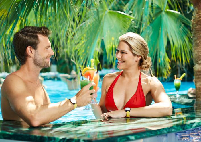 Paar genießen Cocktails in der Therme Euskirchen zwischen Palmen im Pool